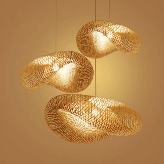 Three woven bamboo pendant lights hanging against a beige backdrop, illuminated from within.