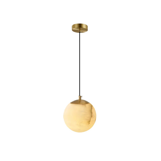 Gold-colored pendant lamp with smooth finish and circular shade, suspended by a black cord.