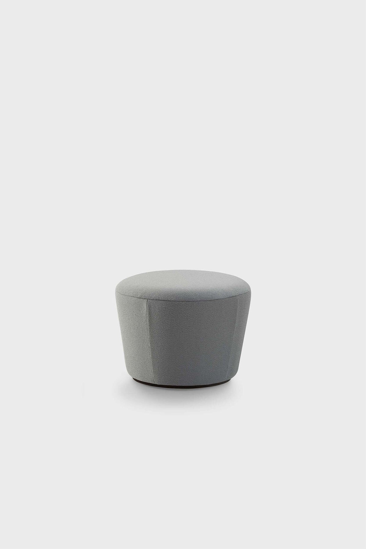 A small, round, fabric pouf with a rounded top and slightly rounded sides, in a light grey color against a plain white background