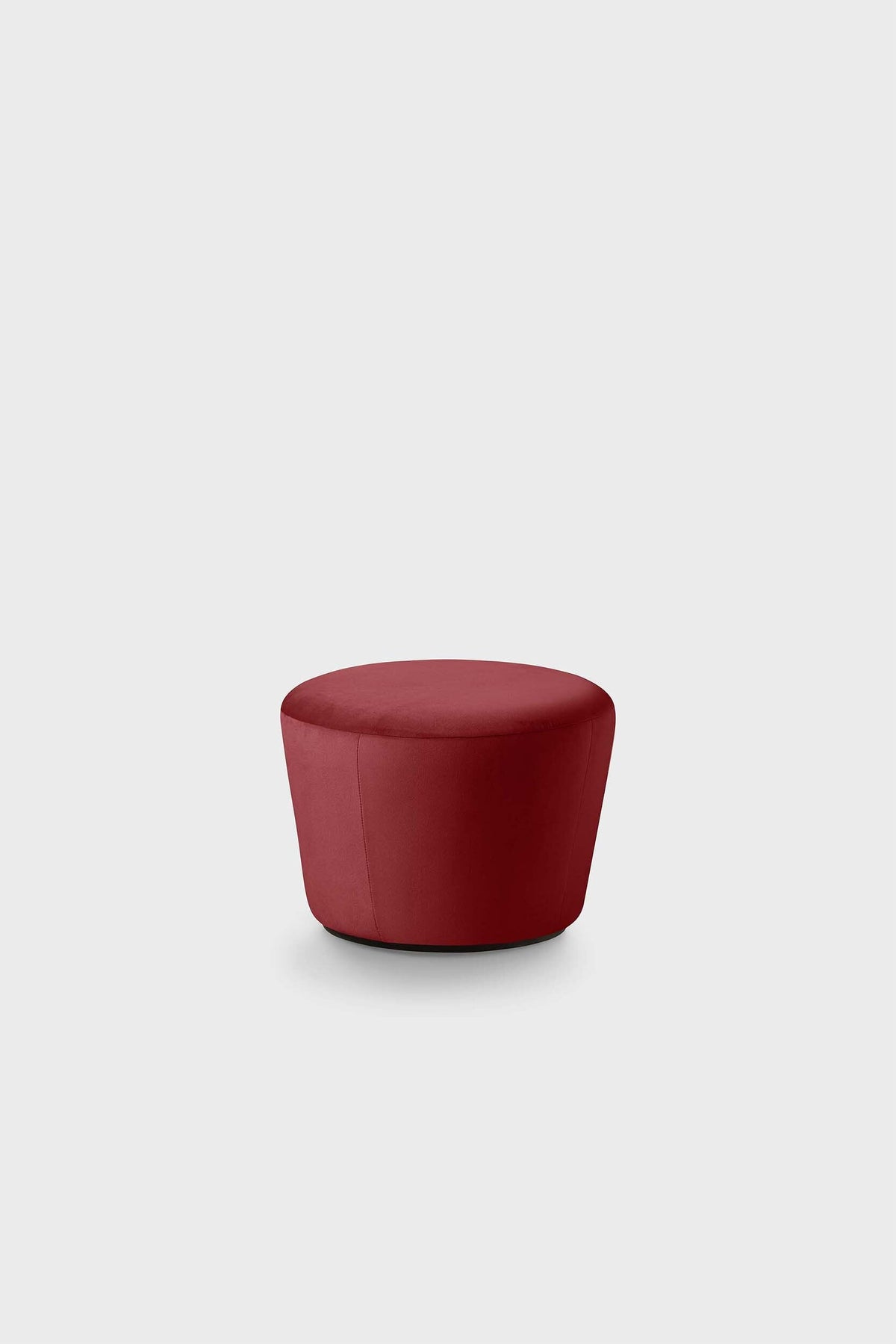 An elegant red pouf with a circular shape against a neutral background.