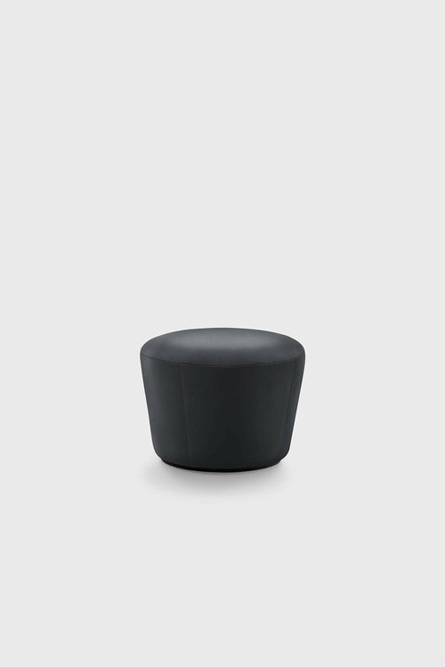 A simple black pouf with a rounded top, likely made of leather, on a plain white background.
