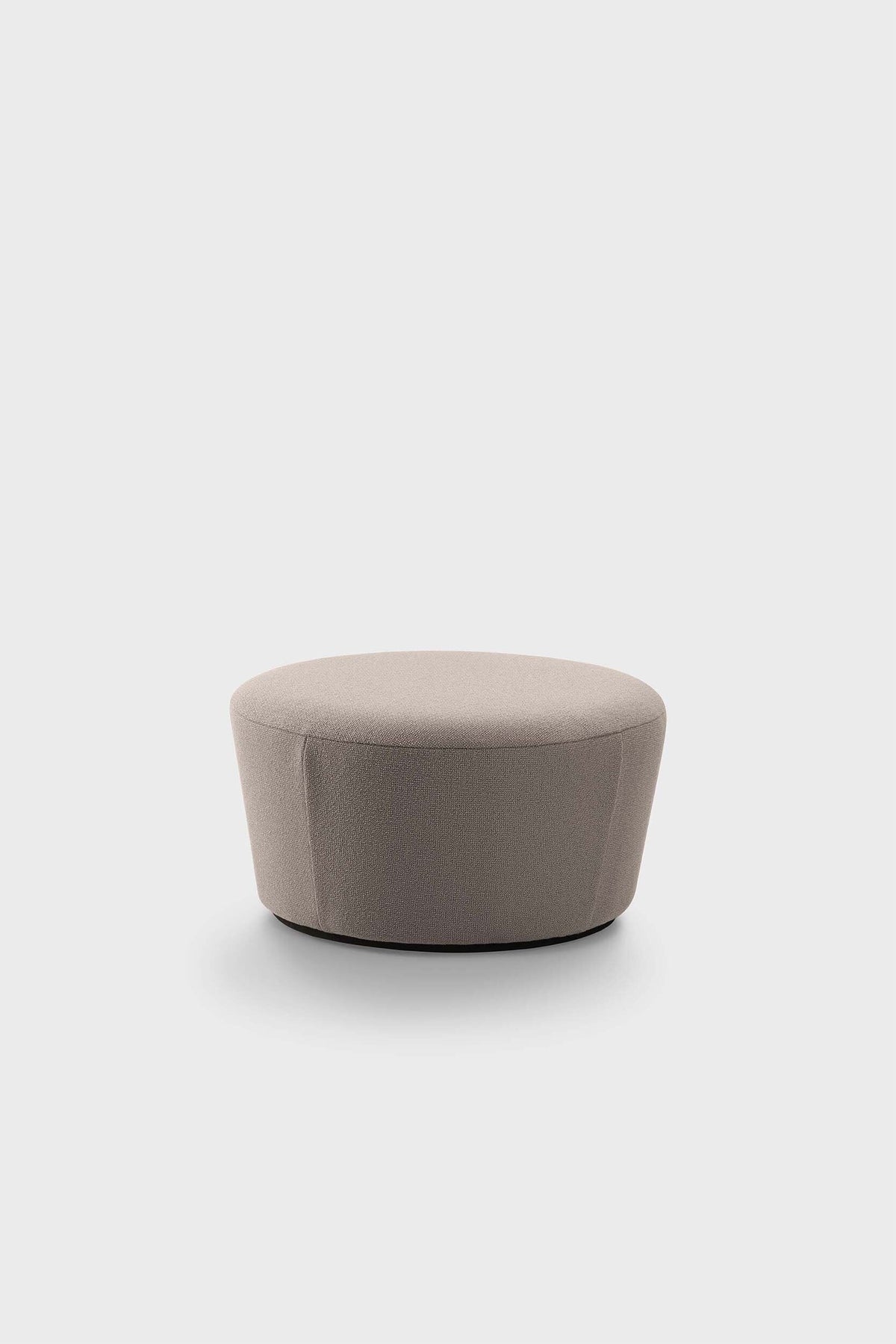 A light brown circular pouf on a plain surface