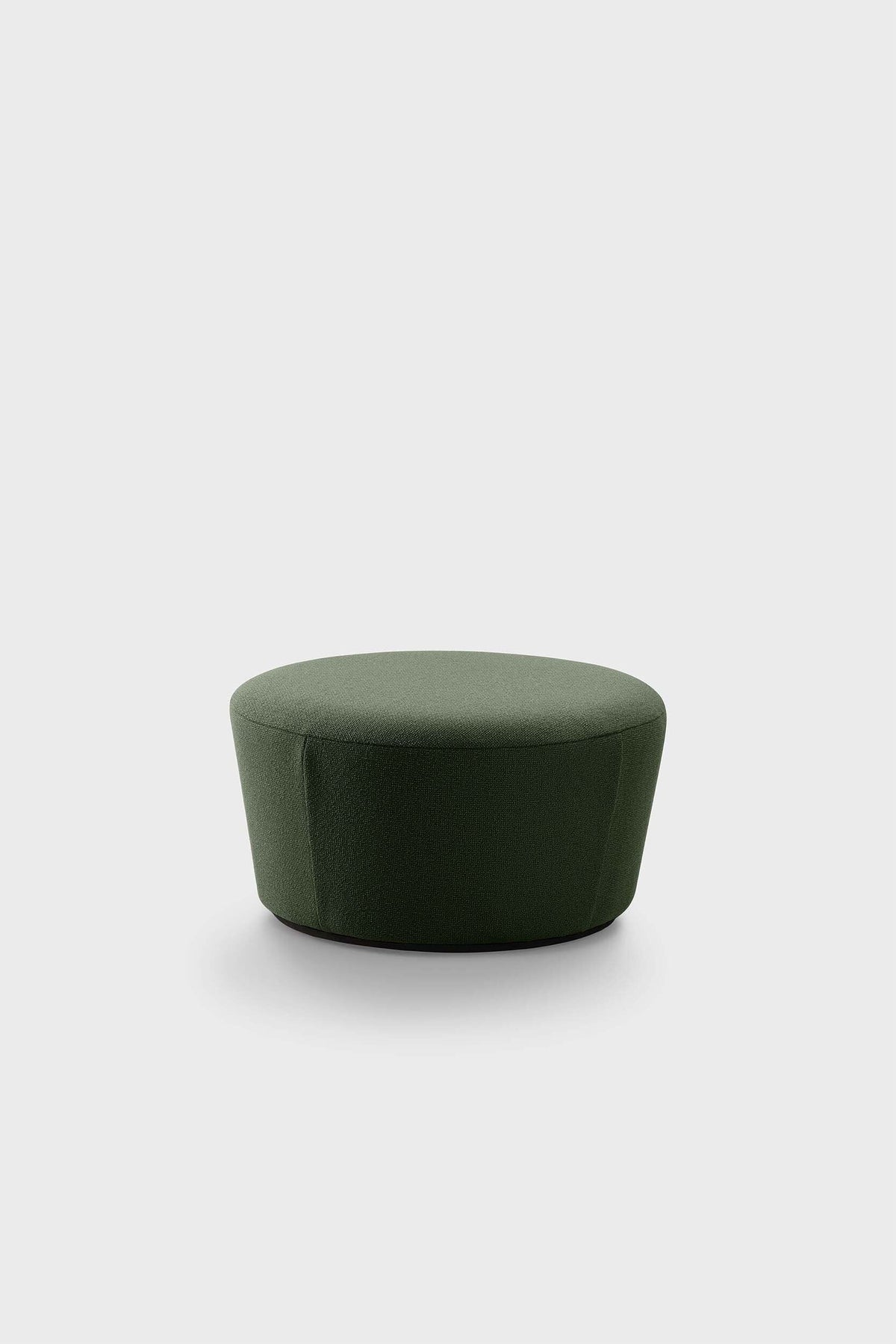A small, round, dark green pouf against a neutral background
