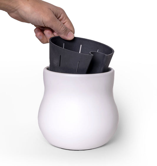 White ceramic planter with rubber liner being inserted by a hand