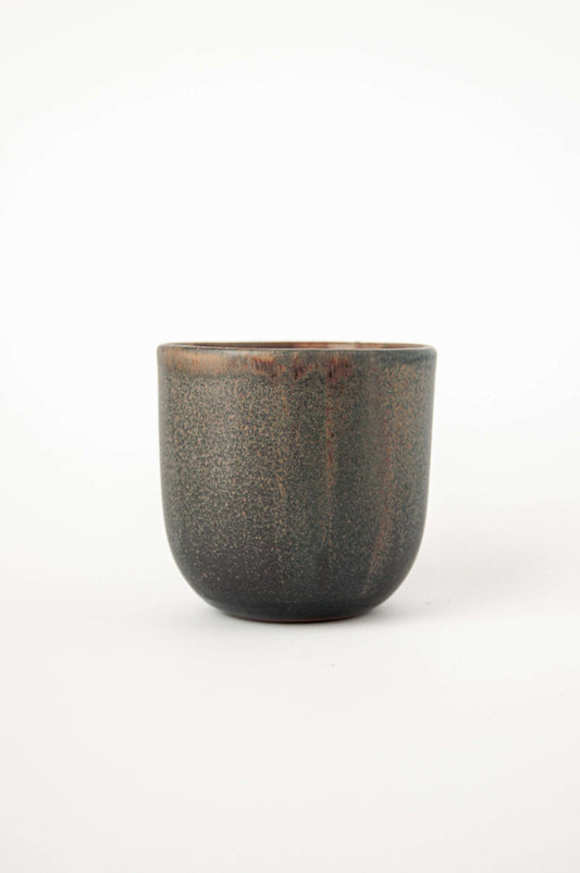 A rustic stoneware coffee cup with a dark brown speckled finish against a white background.