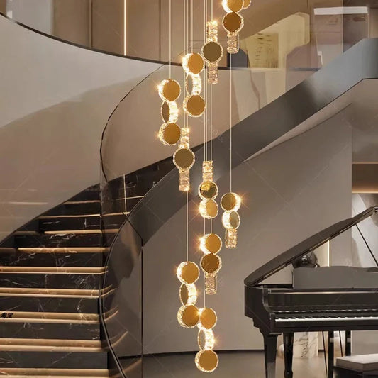 Modern crystal chandelier with gold accents hanging from ceiling over staircase and piano.