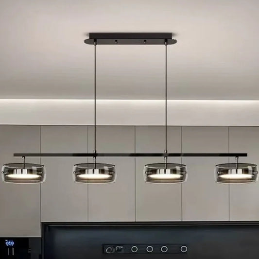 Modern glass pendant lights with metallic finishes hanging above a countertop in a kitchen setting.