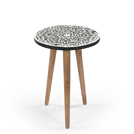 A small round side table with black and white floral bone inlay design and wooden legs.