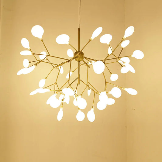 A Nordic Modern ceiling chandelier with a golden frame and frosted glass droplets, suspended in a corner of a room with beige walls.