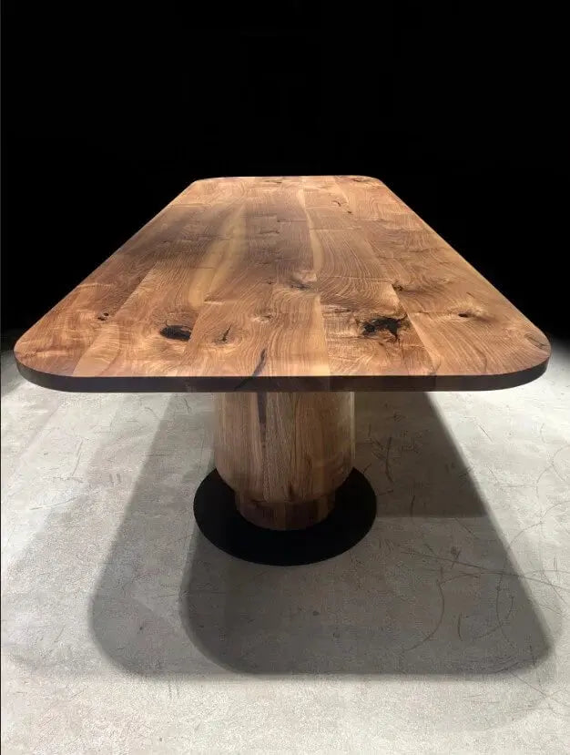Walnut dining table with tulip pedestal legs photographed from the end