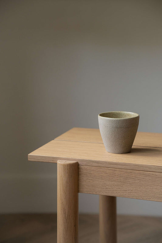 Stony mug on wooden table, beige finish, light grey, neutral background
