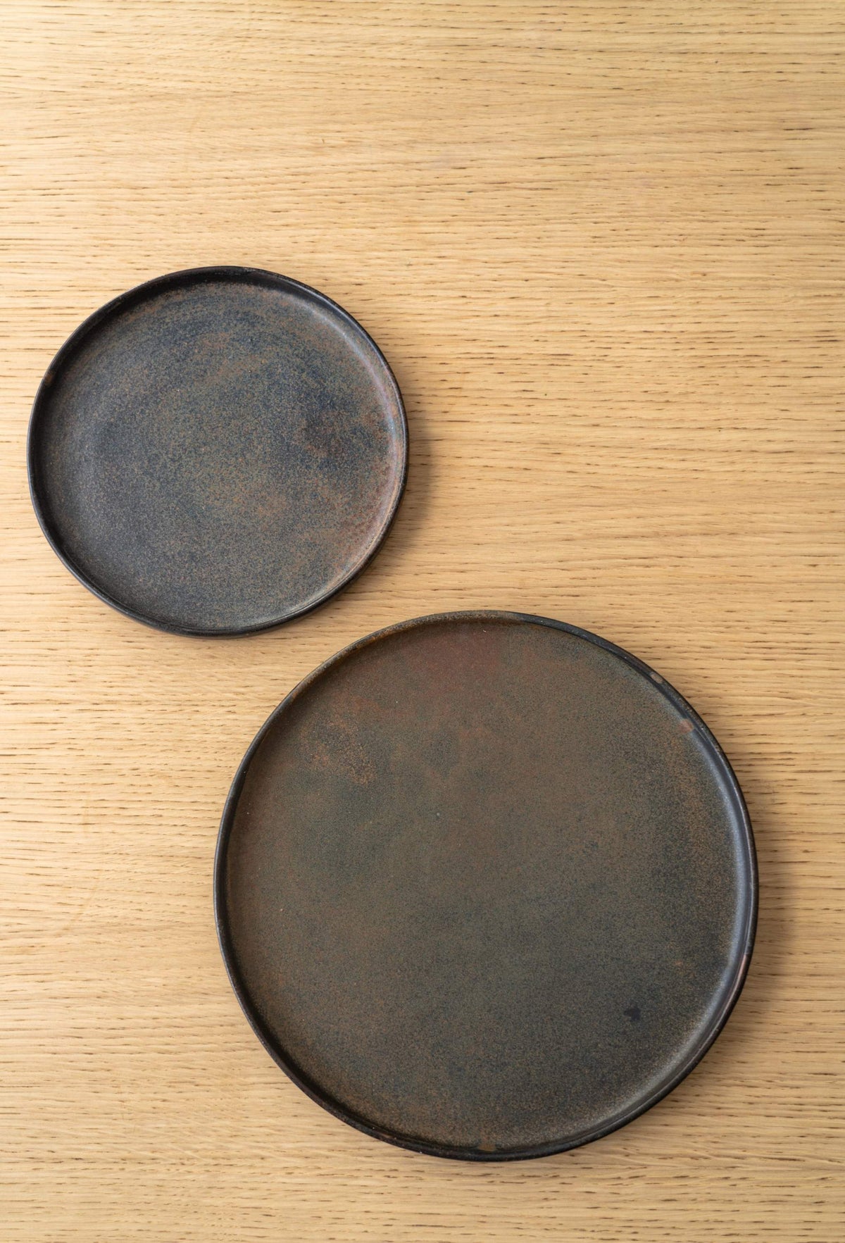 Circular stoneware plates with rustic finish on wooden surface