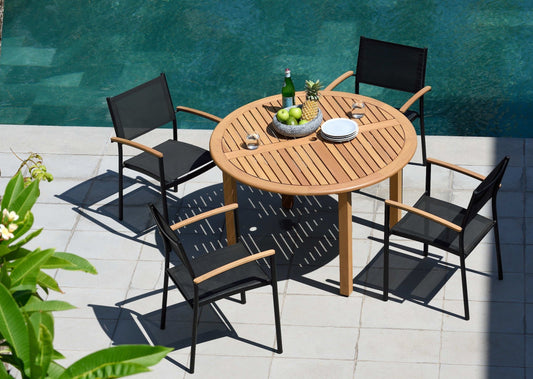 Wooden table and four armchairs near a pool