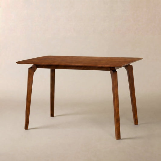A simple wooden dining table with four sturdy legs, placed against a plain backdrop.
