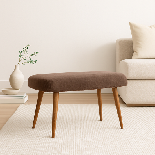 Rectangular brown bench with wooden legs on a white rug in a minimalist living space