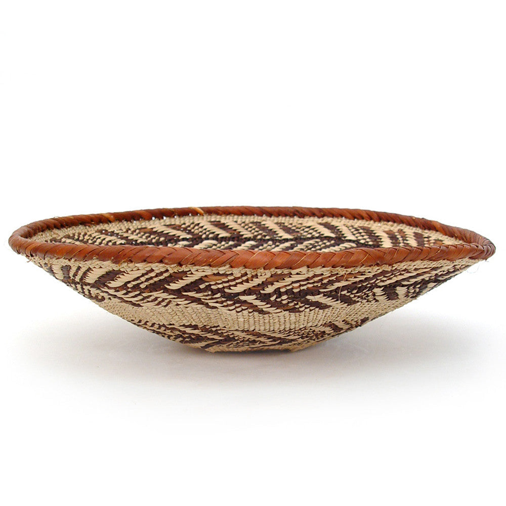 Woven basket with intricate pattern, brown and beige, plain background
