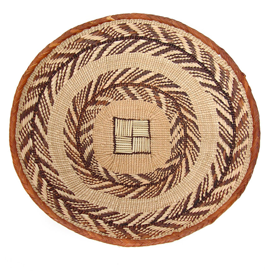 A woven Tonga Basket - Small, featuring a geometric pattern with shades of brown and beige, viewed from the top against a white background.