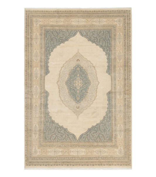 A large Persian rug with intricate designs in oatmeal, light blue, and beige tones, displayed against a plain white background.