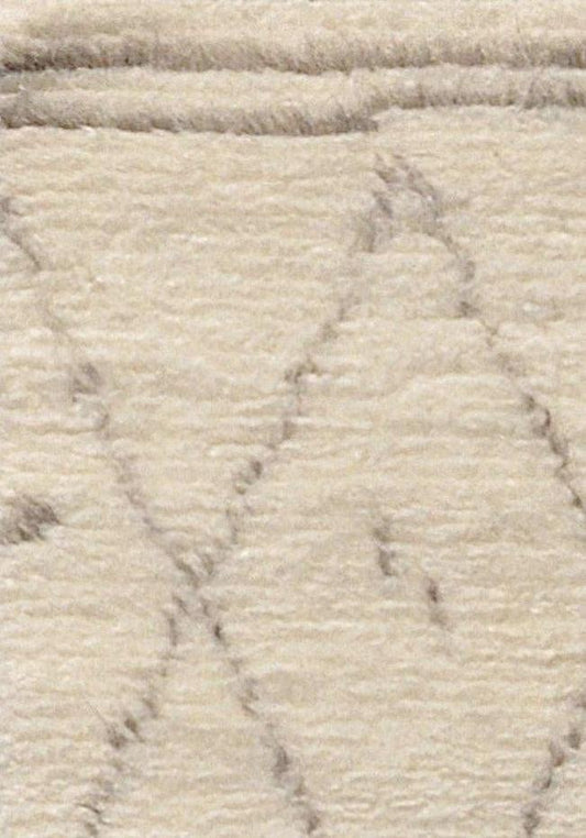 Close-up of a hand-knotted Moroccan rug with a geometric pattern using silk and wool, featuring muted tones.