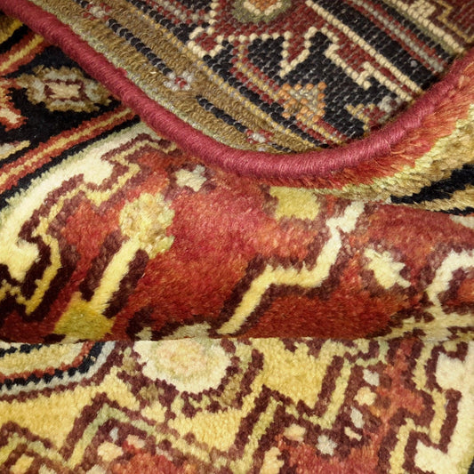 Close-up of a handmade rug with intricate patterns in warm earth tones.