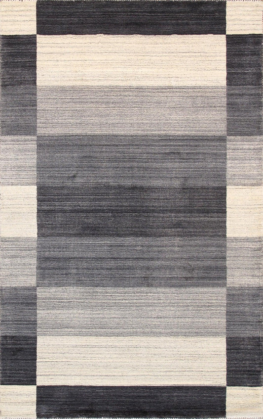 A modern hand-loomed rug with striped black, white, and gray patterns