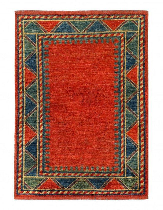Vintage Turkish rug with red field and geometric borders, featuring red, green, blue, and gold colors on a white background.