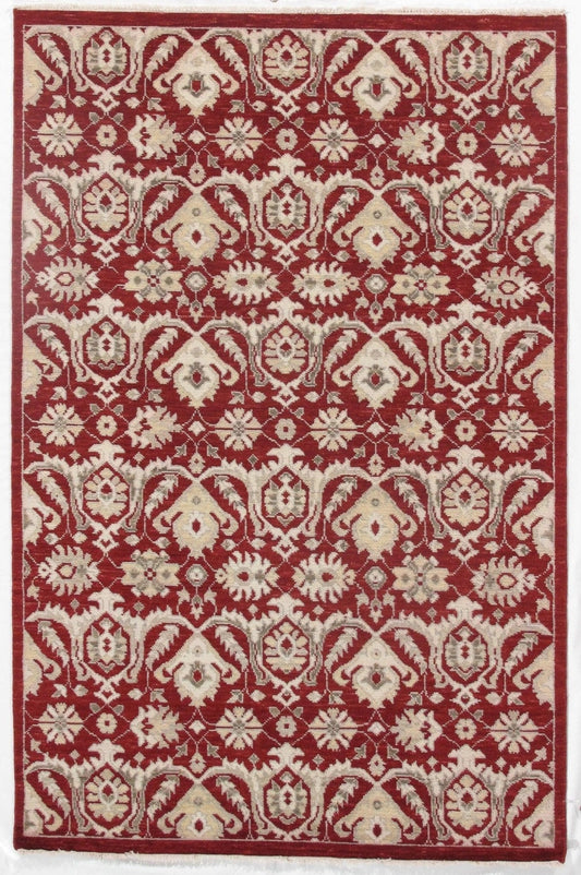 Red rug with intricate floral designs and cream accents