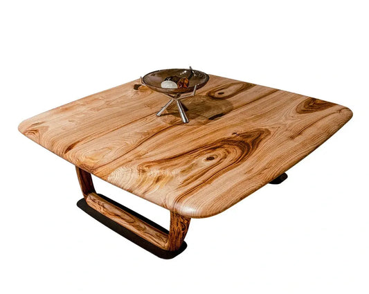 Rustic solid chestnut wood coffee table with a bowl and other items on it, with a white background.