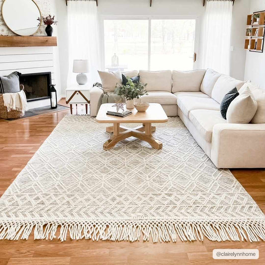 Ossun Wool Rug with Tassels on hardwood floor in modern living room with white couch and wooden coffee table