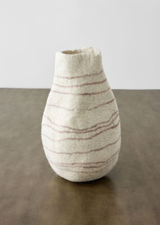 A textured wool gourd basket with diagonal stripes on a dark surface against a plain background.