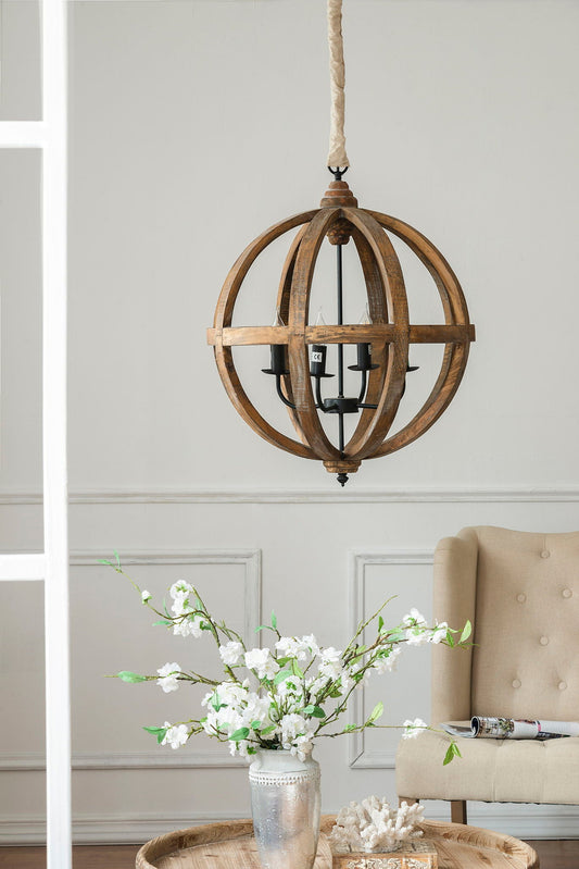A 4 Light Wood Chandelier hanging from a rope chain, set against a neutral wall. A vase with white blossoms and green leaves sits on a wooden table below.
