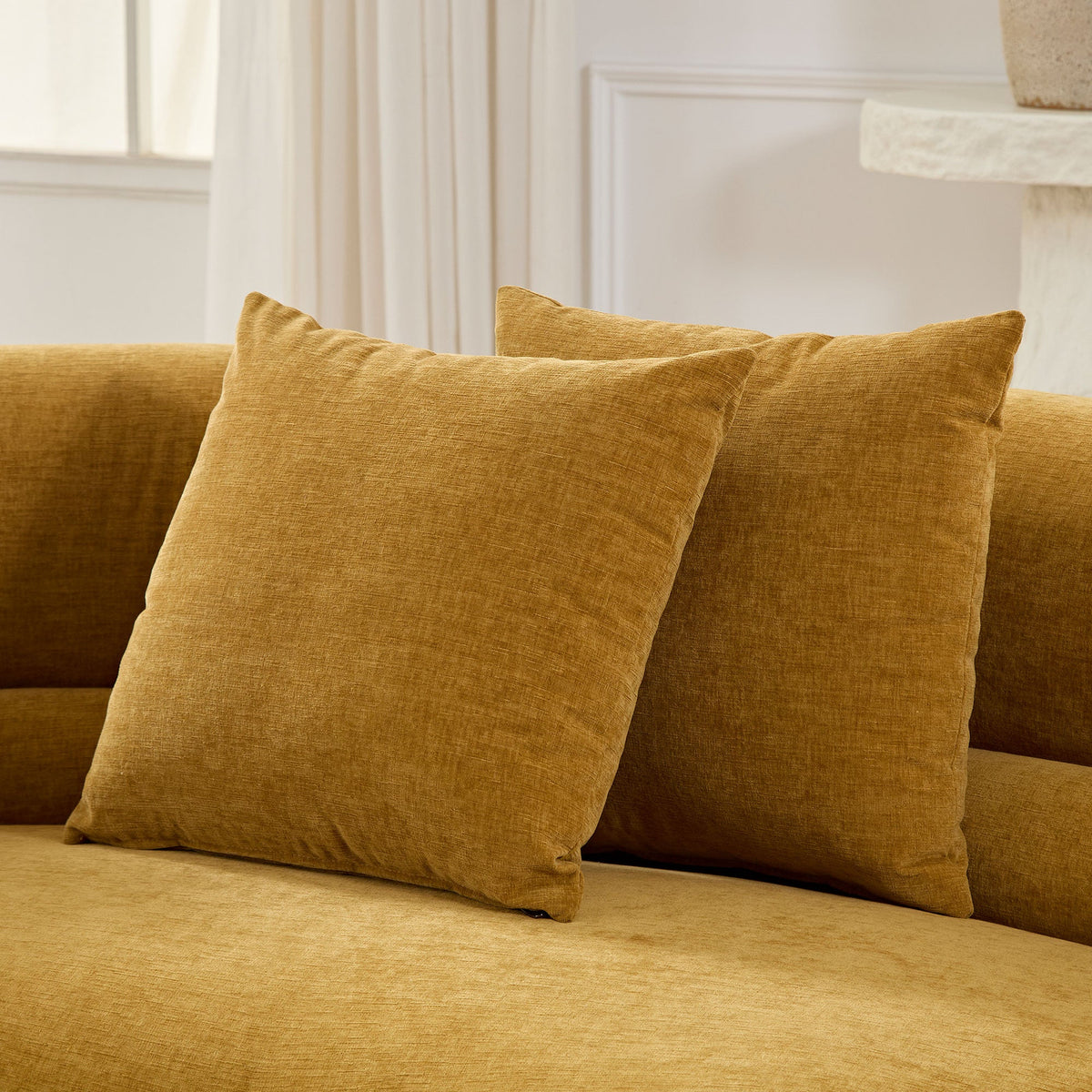 Mustard yellow pillows on a sofa in a minimalist living space