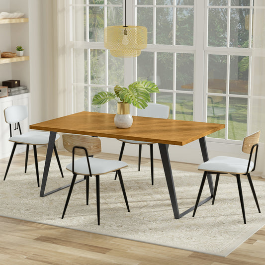 Modern dining setup with a wooden table, black legs, white cushioned chairs, a gold vase with green leaves, and a pendant light above