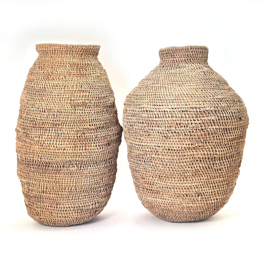 Two large woven baskets with natural texture against a plain background.