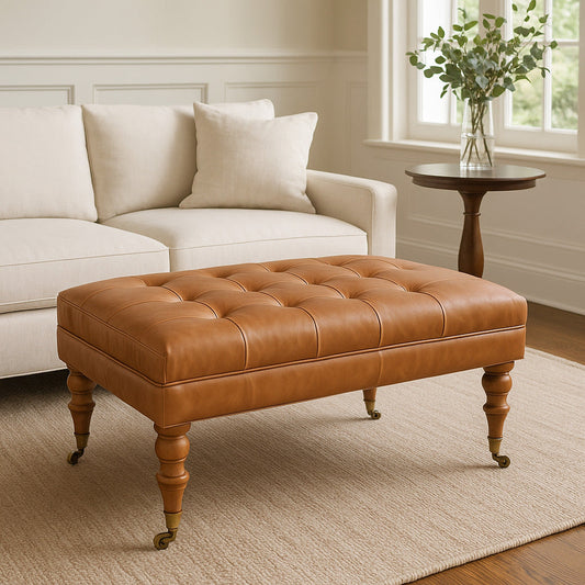 Rectangular ottoman with button-tufted leather top and castor腿, brown, in a living room, white couch, pillow.
