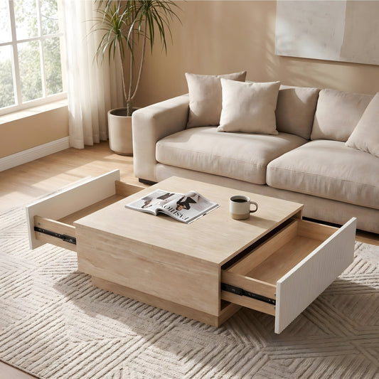 A light wood coffee table with two open drawers, set in a living room with a beige sofa and a small plant.