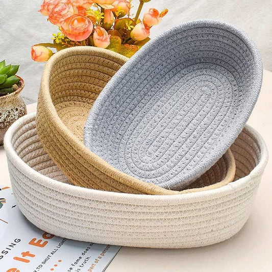 Handcrafted oval jute baskets in different shades arranged, decorative flowers and succulent in background.