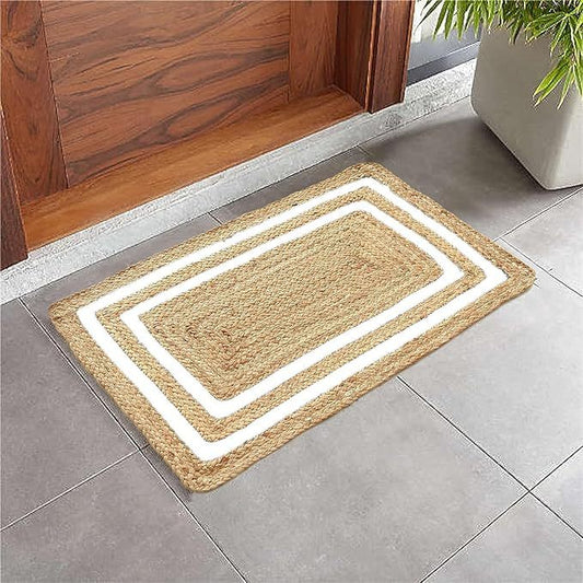 Handloom jute mat with white rectangular borders in front of a wooden door and on a tiled floor