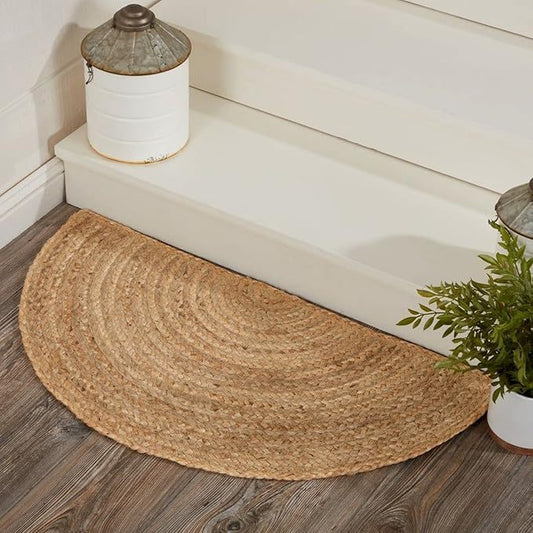 Natural half-circle woven jute rug on a wooden floor near a bathtub, surrounded by rustic decor.