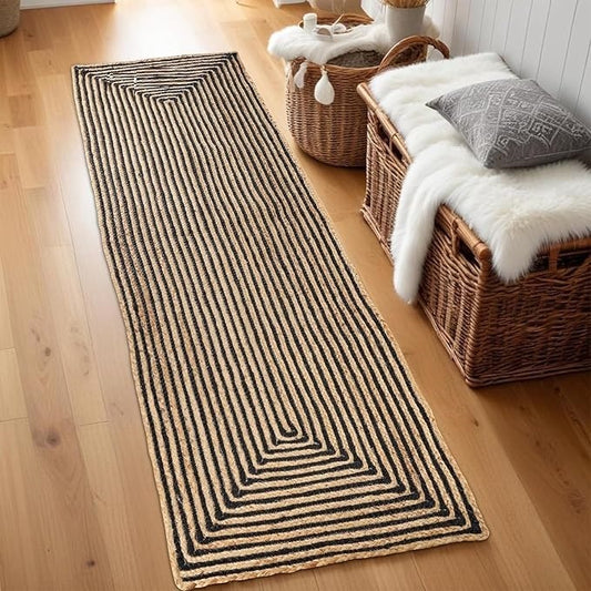 A jute and cotton rug with a geometric design on wooden floor, next to a basket and a cushion.