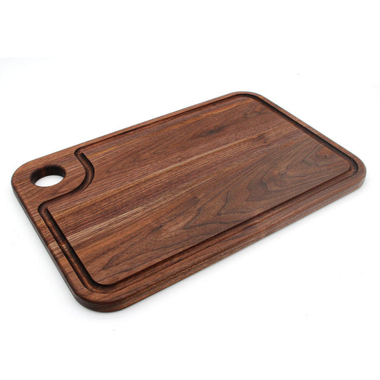 Rectangular dark wood cutting board with thumb hole and juice groove, 18x12 inches.