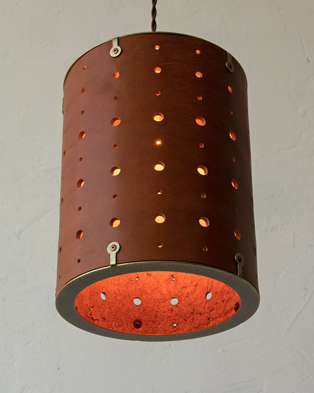 Leather Drum Pendant Light Perforated Plug-In, Tan leather, lit from below