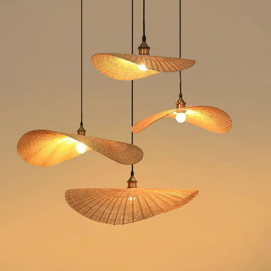Wabi-Sabi rattan pendant lights with curved woven shades, hanging in a warm, plain background.