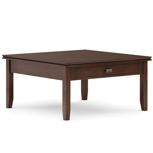 Light brown square coffee table with a simple drawer and thin legs against a white background.