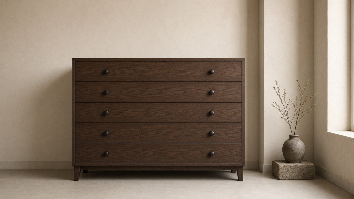 Robyn five-drawer dark walnut chest in empty bedroom, warm plaster walls, soft daylight