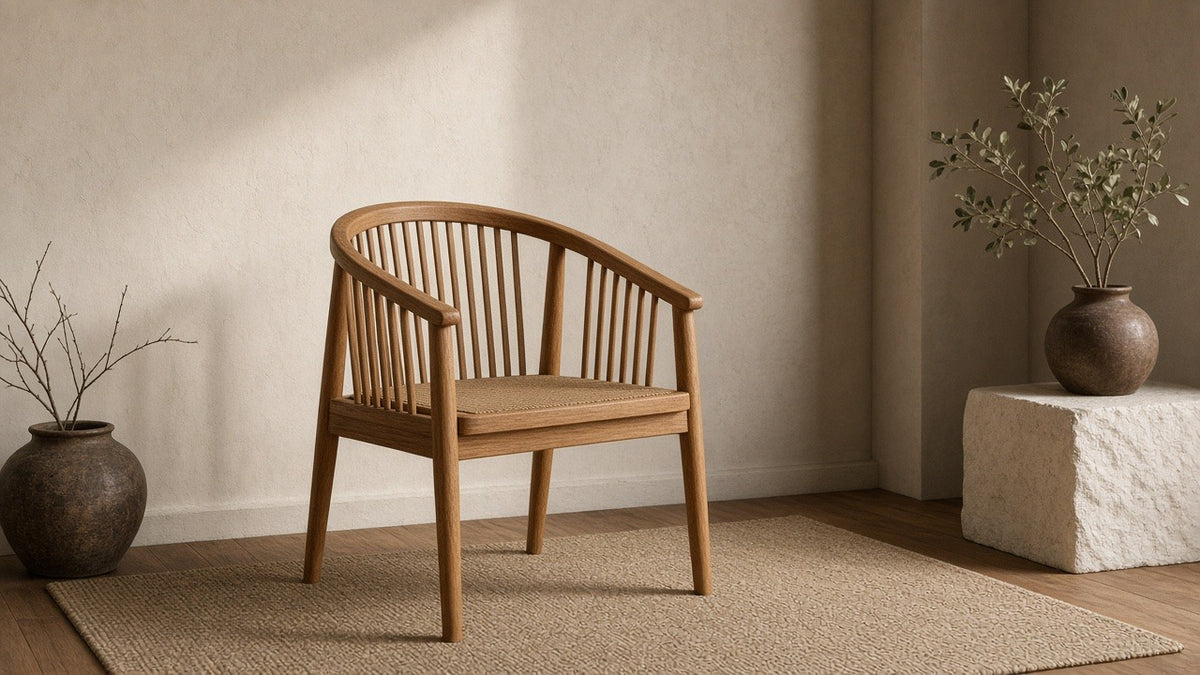 Teak round-back arm chair in empty living room, warm plaster walls, soft daylight