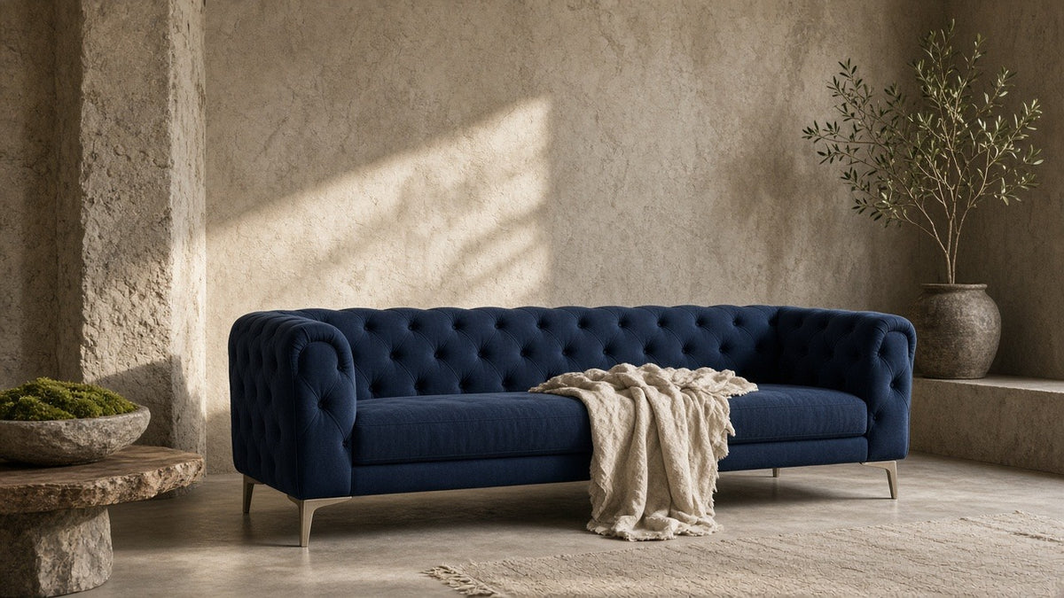 French navy tufted Montgomery sofa in a quiet plaster living room