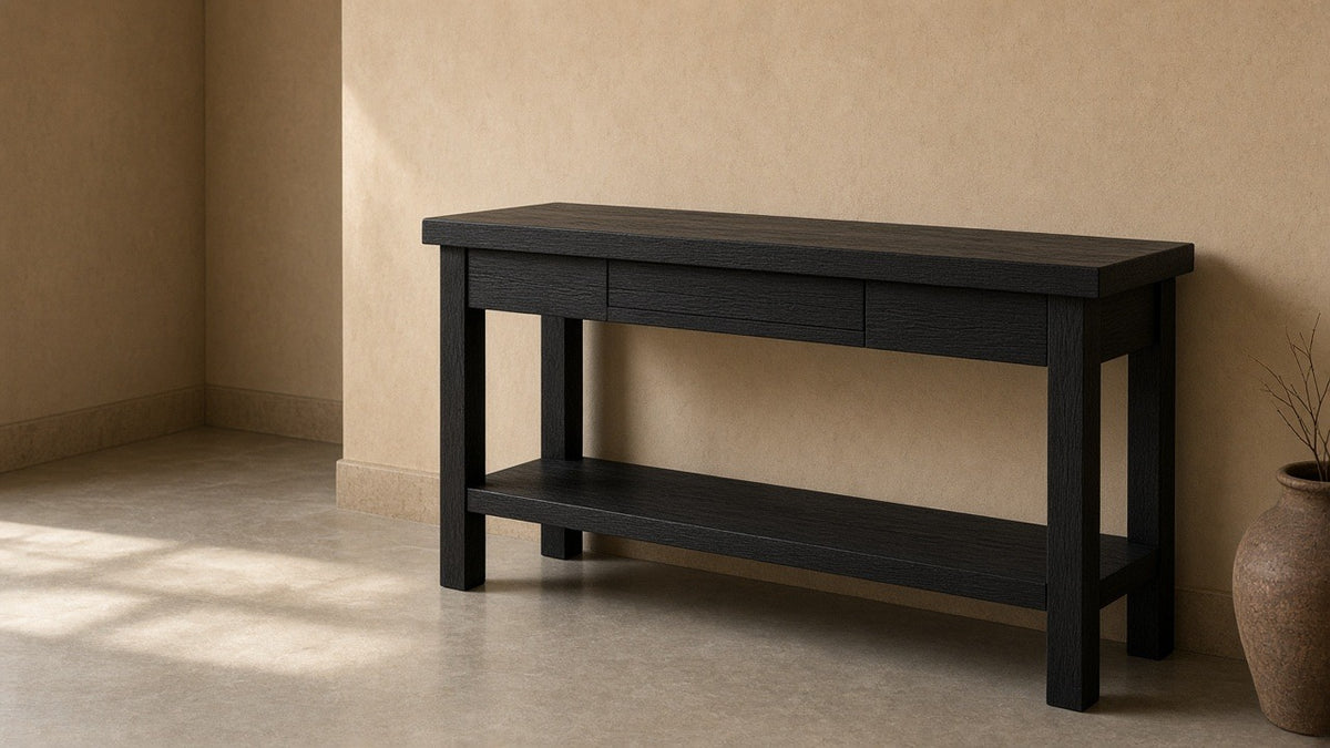 Grackle solid wood black console table in empty entry hall, warm plaster walls, soft daylight