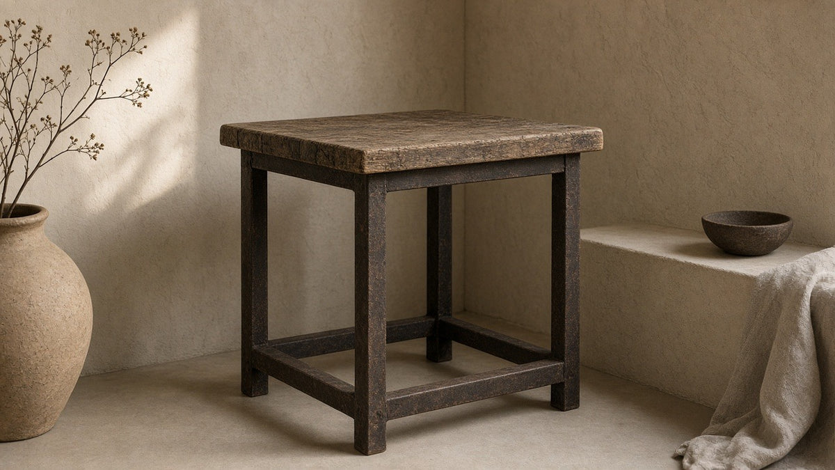 Industrial reclaimed wood and iron side table in empty living room, warm plaster walls, soft daylight