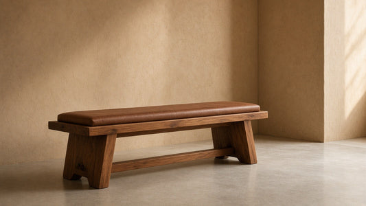 Solid wood chestnut bench with leather seat pad in empty hall, warm plaster walls, soft daylight